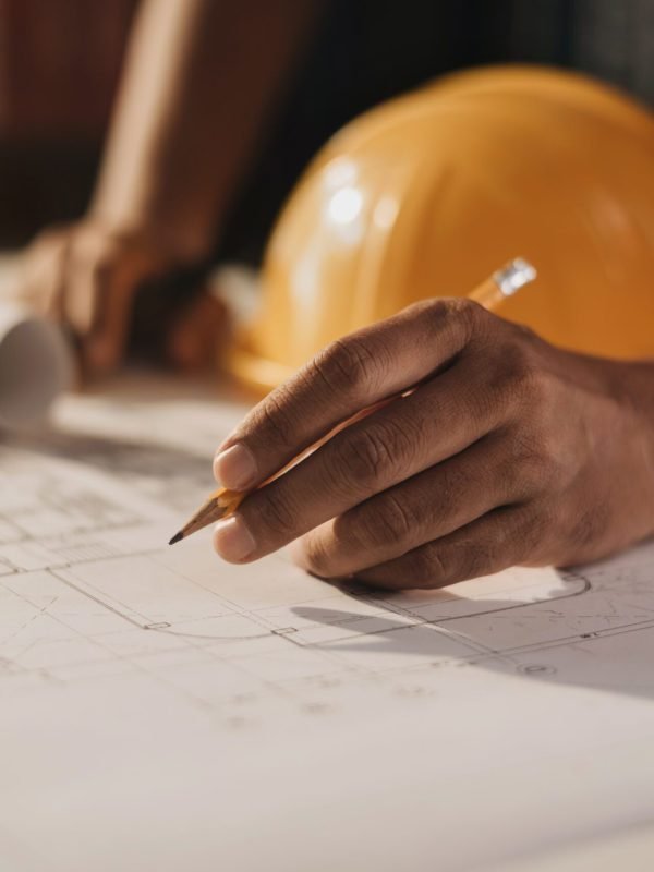 Concept architects or engineer holding pen pointing equipment architects on the desk with a blueprint in the office.